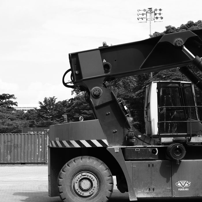 Black and white photo of an industrial crane in Ipoh, Malaysia with a serene backdrop.